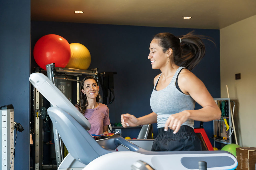 Dr. Leibler guiding a runner on a treadmill during the execution of a recovery plan at Fit & Function in Boise.