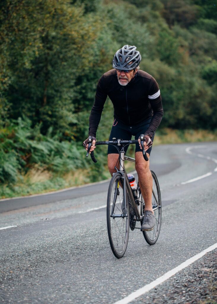 Cyclist pedaling uphill with a determined expression.