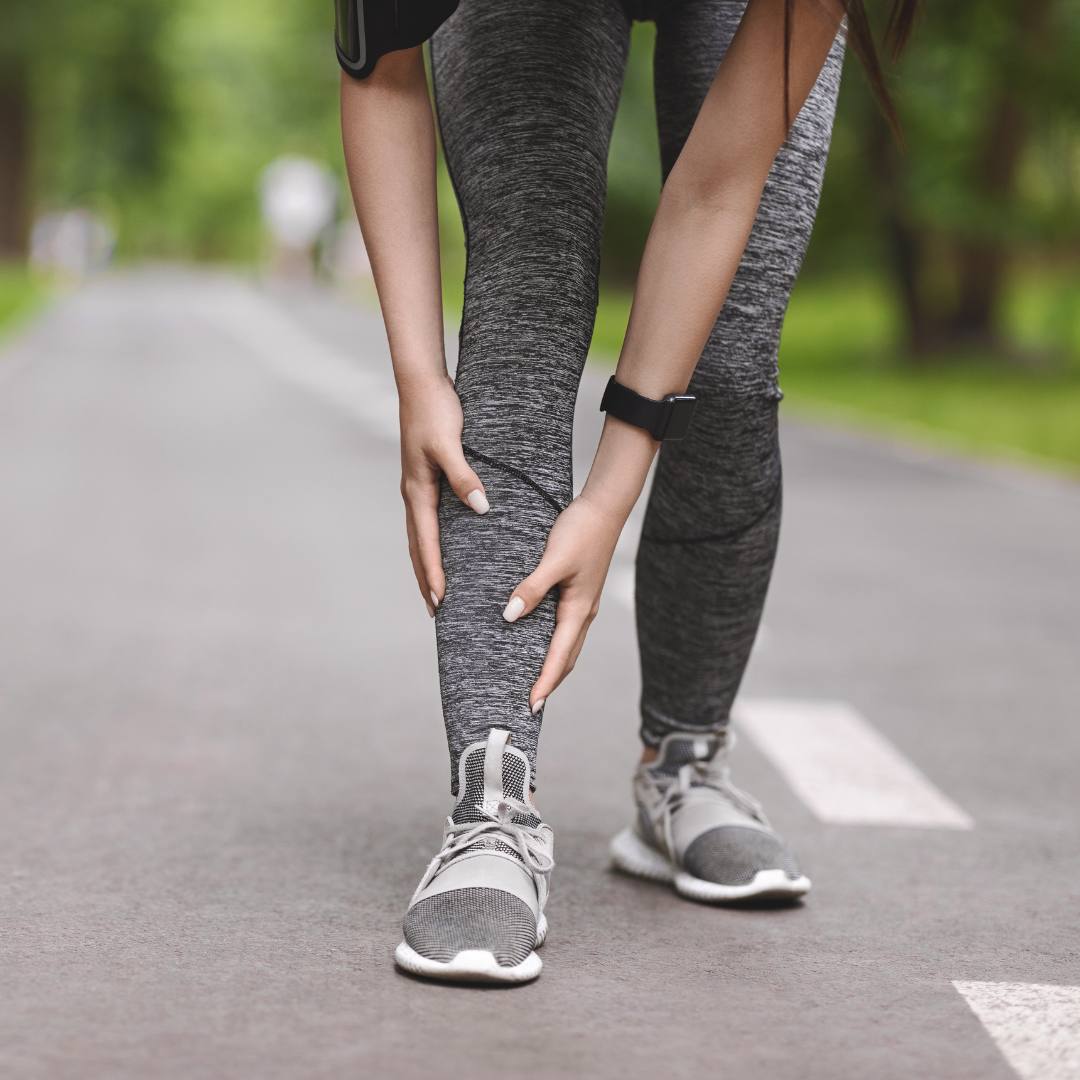 Runner holding shin in pain, a common sign of shin splints.