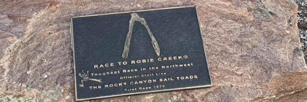 The Race to Robie Creek banner draped over a large rock, marking the event's presence in Boise’s toughest half marathon.